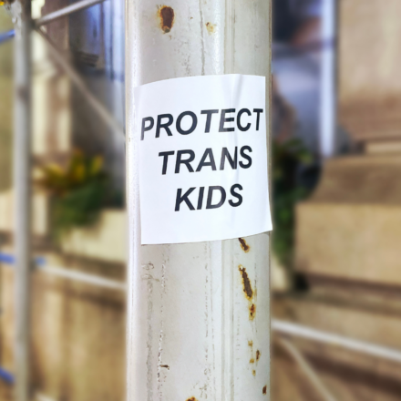 Photo of a scaffolding pole with a sticker that says "Protect Trans Kids"